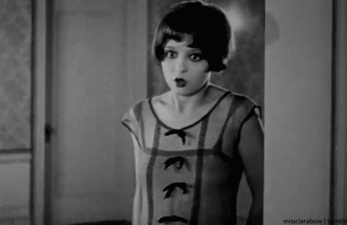 A silent movie gif of an actress placing a finger on her lips, saying 'ssh'!
