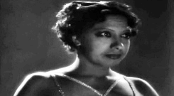 Gif of Josephine Baker, biting her lip and looking like she has butterflies.