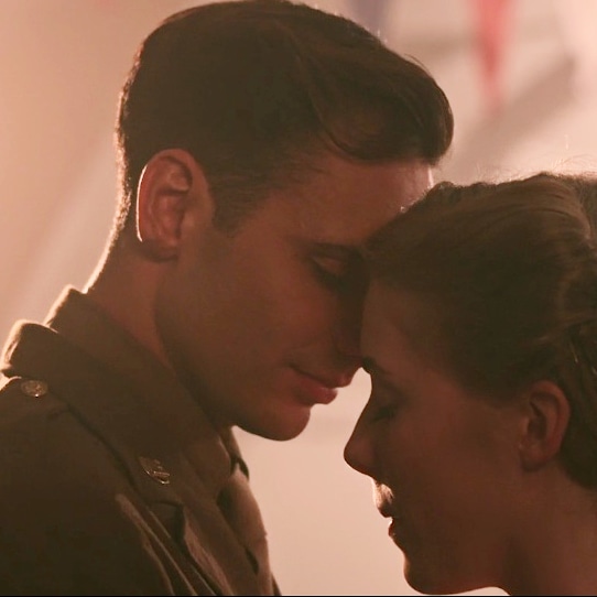 Mateo Oxley in a still from independent WWII film ‘Magpie.’ He is dressed as a GI, his hair cropped and his face clean-shaven, dancing with a young woman, their heads together. He is taller than her, his forehead resting on the top of hers.